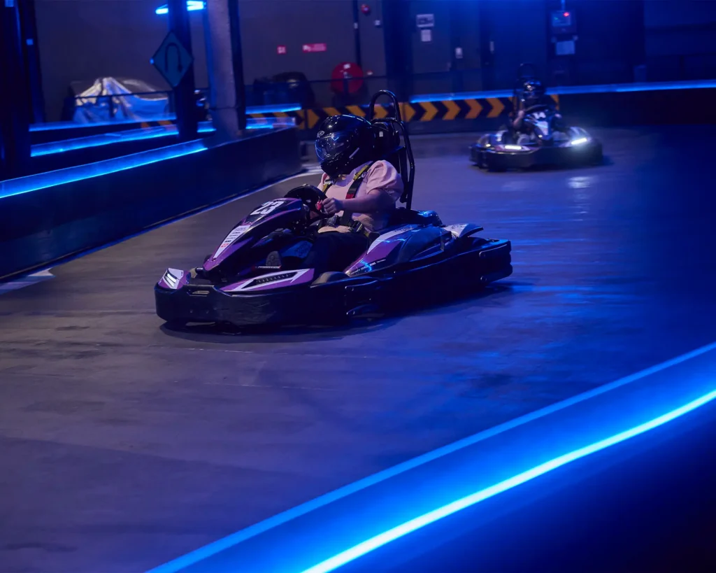Woman in pink shirt racing on neon-lit track