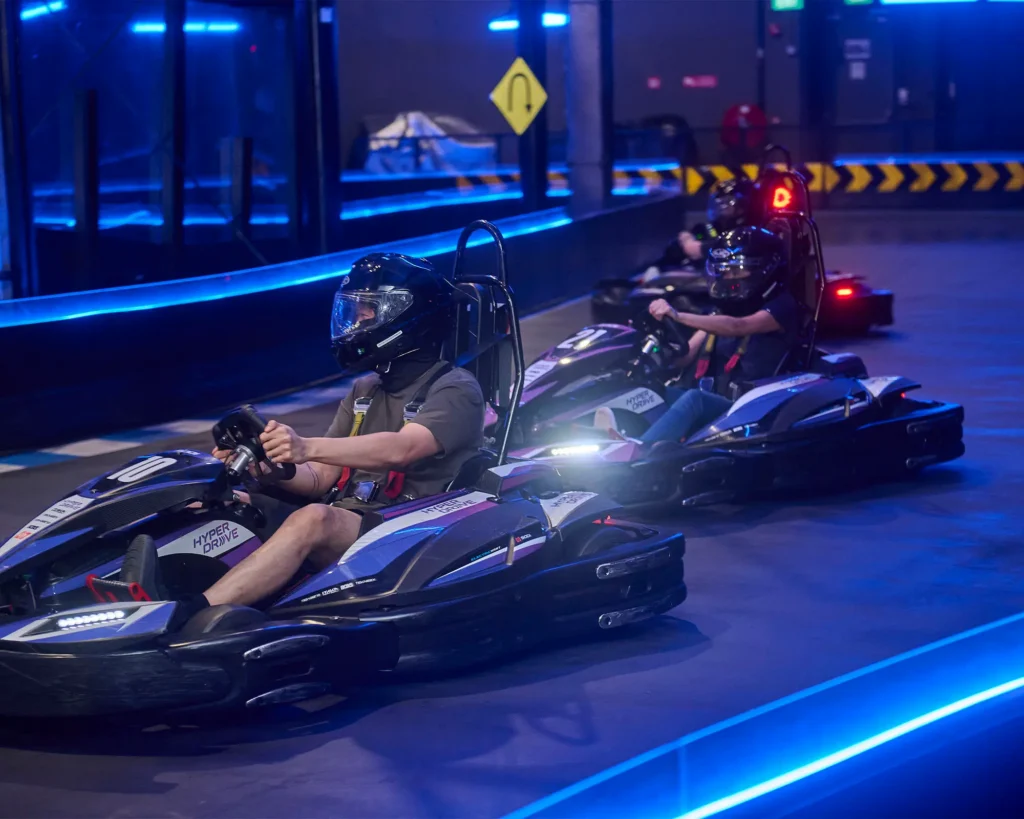 Several racers make turn on neon-lit race track